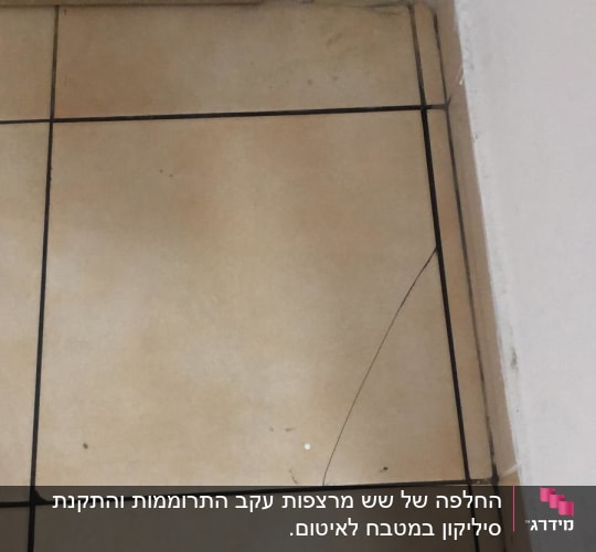 רצפה עם אריח סדוק ליד דלת עץ